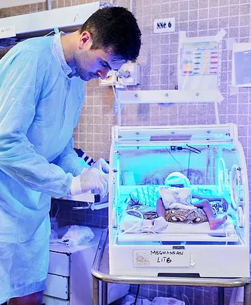 Pablo Sánchez revisa una incubadora IncuNest con un bebé en el hospital de Afagnan